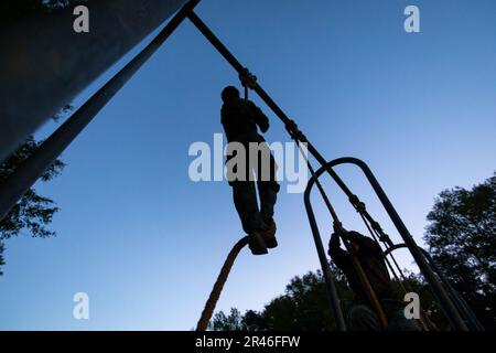 1. LT. Kelly Owen, ein Mörserzugs-Kommandant vom 2. Bataillon, 7. Marines Regiment, 1. Marine Division, klettert ein Seil hoch, während die Sonne am zweiten Tag des besten Mörserwettbewerbs über Fort Benning, Georgia, am 11. April 2023 aufgeht. Owens Team, eines der drei Teams, die während des Wettbewerbs das United States Marine Corps repräsentierten, endete am ersten Tag als eines der zehn besten Teams, die um den Titel „Bestes Mörtelteam“ wetteiferten. Stockfoto