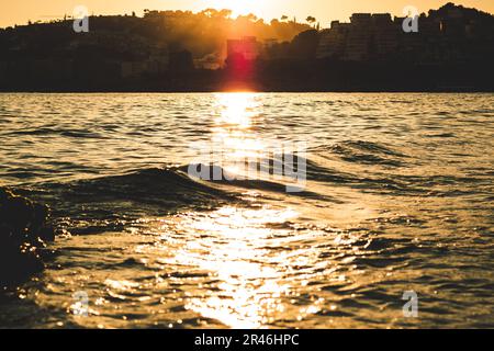 Ein lebhafter Sonnenuntergang mit Orange- und Gelbtönen am Calabajio Beach in Almunecar, Granada Stockfoto