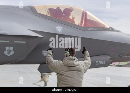 Ein Besatzungschef der 158. Fighter Wing Maintenance Group signalisiert LT. Colonel Robert Peel, einem F-35A Lightning II Piloten, der der 134. Fighter Squadron, 158. Fighter Wing, zugewiesen wurde, bevor er zu einer Ausbildungsmission von der Vermont Air National Guard Base, South Burlington, Vermont, April 3, abhebt. 2023. Die Ausbildungsmission ist eine Ausbildungsübung zur Agile Combat Employment. Stockfoto