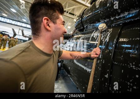 USA Army SPC. James Payne, UH-60 Helikopter-Reparateur mit dem 1. Assault Helicopter Bataillon, 150. Aviation Regiment, wäscht einen UH-60m Black Hawk auf der Joint Base McGuire-Dix-Lakehurst, New Jersey, 10. April 2023. Die Black Hawks werden regelmäßig gewaschen, um Korrosion und Schäden zu verhindern und die Einsatzbereitschaft aufrechtzuerhalten. Stockfoto