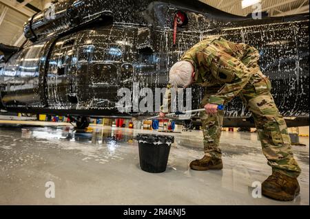 USA Army Staff Sergeant Daniel Montgomery, UH-60 Helikopter-Reparateur mit dem 1. Assault Helicopter Bataillon, 150. Aviation Regiment, wäscht einen UH-60m Black Hawk auf der Joint Base McGuire-Dix-Lakehurst, New Jersey, 10. April 2023. Die Black Hawks werden regelmäßig gewaschen, um Korrosion und Schäden zu verhindern und die Einsatzbereitschaft aufrechtzuerhalten. Stockfoto