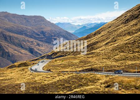 Die Autos fahren entlang der malerischen Crown Range Road in der Nähe von Queenstown in Neuseeland Stockfoto