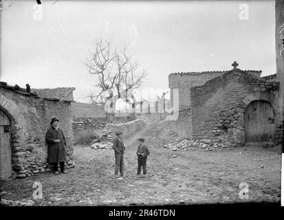 UN Home i dos nens en un carrer de Barasona al costat de la porta del cementiri Stockfoto