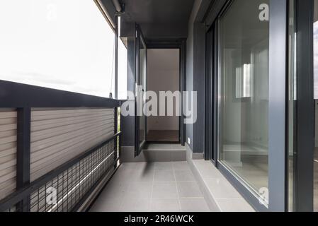 Kleine Terrasse mit grauen Schiebetüren aus Aluminium und einer Falttür Stockfoto