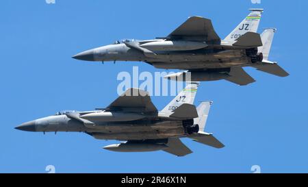 Die zwei militärischen Kampfjets fliegen durch einen klaren, blauen Himmel. Stockfoto