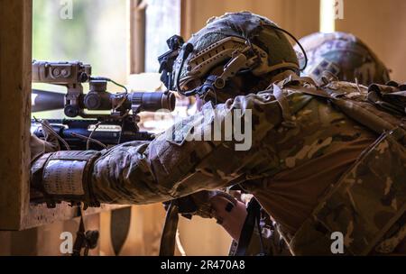 SPC. Tyler Wischerman, Soldat des 2. Geschwaders, 1. Kavallerie-Regiment, 1. Stryker-Brigade-Kampfteam, 4. Infanterie-Division, greift das Ziel während des internationalen Sniper-Wettbewerbs 2023 in Fort Benning, Georgia, am 11. April 2023 an. Die Scharfschützen beim Wettkampf mussten wichtige Kampffähigkeiten unter Beweis stellen, einschließlich Tarnung, Aufklärung, Fitness und die Fähigkeit, sich unter Druck anzupassen. Stockfoto