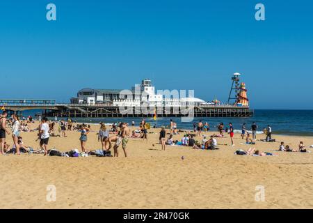 Bournemouth, Großbritannien - Mai 26. 2023: Menschen am Strand vor dem Bournemouth Pier. Stockfoto