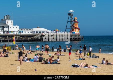 Bournemouth, Großbritannien - Mai 26. 2023: Menschen am Strand vor dem Bournemouth Pier. Stockfoto