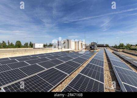 Ausrichtung der kürzlich installierten Solarpaneele auf dem Dach eines Bürogebäudes auf den Boden mit Kies bedeckt Stockfoto