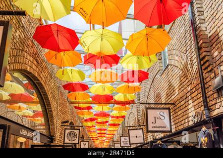 London, Großbritannien - 23. Mai 2023: Farbenfrohe Regenschirme hängen vom Dach des Camden Town Market Stockfoto