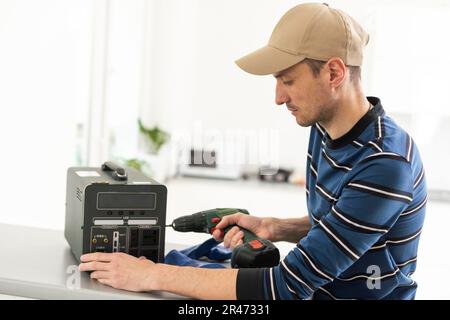 Ein Handwerker repariert eine tragbare Ladestation Stockfoto