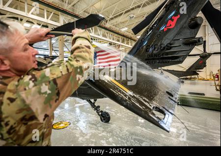 USA Army Staff Sergeant Daniel Montgomery, UH-60 Helikopter-Reparateur mit dem 1. Assault Helicopter Bataillon, 150. Aviation Regiment, wäscht einen UH-60m Black Hawk auf der Joint Base McGuire-Dix-Lakehurst, New Jersey, 10. April 2023. Die Black Hawks werden regelmäßig gewaschen, um Korrosion und Schäden zu verhindern und die Einsatzbereitschaft aufrechtzuerhalten. Stockfoto