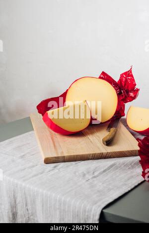 In Scheiben geschnittener Edamskäse, mit roter Wachsschicht bedeckt. Stockfoto