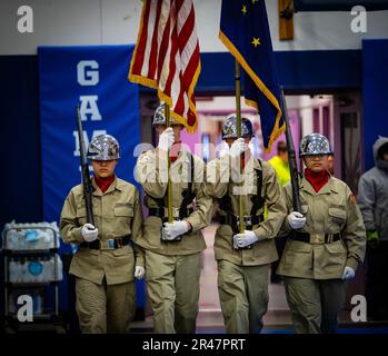 Die Kadetten der Alaska Military Youth Academy präsentieren die Farben während der Alaska Heroism Medal Ceremony am 28. März 2023 im John Apangalook Memorial High School Gymnasium in Gambell, Alaska. Bei der Zeremonie wurden 16 Pfadfinder der Nationalgarde Alaska für ihren Heldenmut während einer Rettungsmission im Jahr 1955 geehrt, nachdem zwei russische MiG-15s einen US-Dollar abgeschossen hatten Navy P2V-5 Neptunflugzeug fliegt eine routinemäßige Seepatrouille über das Beringmeer mit 11 Seeleuten an Bord. Stockfoto