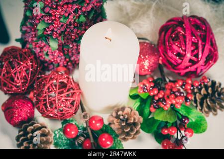 Ein Blick von oben auf festliche Weihnachtskomposition mit brennender Kerze umgeben von dekorativen Elementen Stockfoto