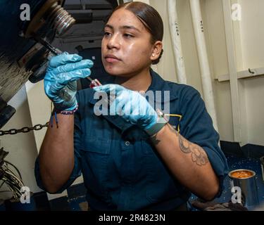 230408-N-NX635-1160 OSTCHINESISCHES MEER (8. APRIL 2023) USA Navy Boatswain's Mate Seaman Gabriela Yanes aus Long Island, New York, entfernt die Armaturen einer gepanzerten Luke zur Schmierung und Wartung an Bord des Flugzeugträgers USS Nimitz (CVN 68). Nimitz ist in der US-7.-Flotte und führt Routineeinsätze durch. 7. Fleet sind die USA Die größte Flotte der Navy, die mit einer Anzahl von Flotten ausgestattet ist, interagiert und arbeitet regelmäßig mit Verbündeten und Partnern zusammen, um eine freie und offene Region im Indo-Pazifik zu erhalten. Stockfoto