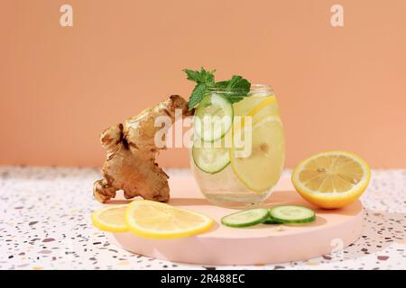 Sassi trinken Diät gesundes Wasser mit Gurkenscheiben, Zitrone und Ingwer. Magisches Schlankheitsgetränk. Auf orangefarbenem Hintergrund, Bereich für Text kopieren Stockfoto