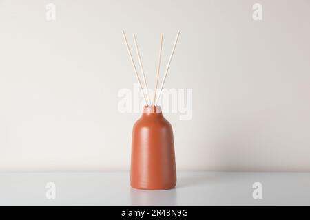 Aromatischer Reed-Lufterfrischer auf weißem Tisch Stockfoto