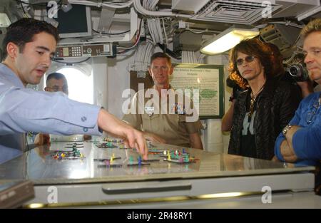 US Navy Steven Tyler (2. von rechts), Leadsänger der Rockband „Aerosmith“, zusammen mit Joey Kramer (rechts), dem Schlagzeuger der Band, machen Sie eine Tour durch die Cockpit Control Stockfoto
