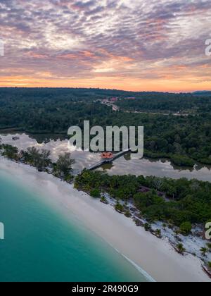 Ein Luftblick auf Koh Rong Beach, umgeben von dichten Bäumen bei Sonnenuntergang Stockfoto