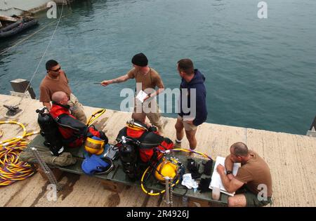 Mitglieder der US Navy des Unterwasserbauteams zwei (UCT-2) hören sich eine Sicherheitsunterweisung von ihrem Tauchleiter an Stockfoto