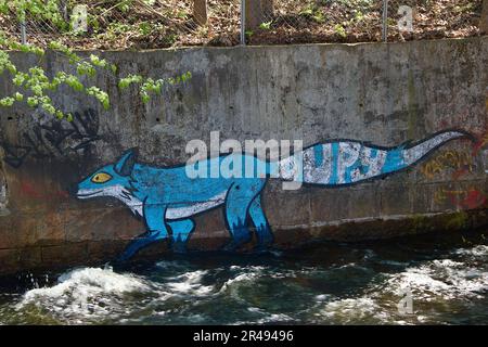 Ein lebendiges Wandgemälde eines Blaufuchs auf der Betonwand eines friedlichen Flusses in Oslo, Norwegen. Stockfoto