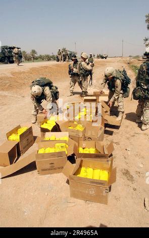 US Navy Fallschirmjäger, die der 82. Luftwaffendivision zugeteilt wurden, öffnen Kisten mit humanitären Rationen für die Verteilung an irakische Bürger im Zentraliraker Stockfoto