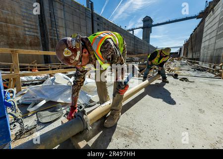 Bauarbeiter führen Arbeiten an Betonfüllungen und an der Wand ausgerichteten Bewehrung und Schalungen für das Projekt Charleroi Lock Construction an den Monongahela River Locks und Dam 4 in Charleroi, Pennsylvania, am 21. März 2023 durch. Die USA Das Armeekorps der Ingenieure im Bezirk Pittsburgh betreibt die Anlage und beaufsichtigte das Bauprojekt in Charleroi zur Verbesserung der Binnenschifffahrt in der Region. Die neu errichtete Kammer soll sich vor dem Sommer mit Wasser füllen, und sie soll 2024 vollständig in Betrieb gehen. Die Bauarbeiten in Charleroi begannen 2004. Wenn Sie fertig sind Stockfoto