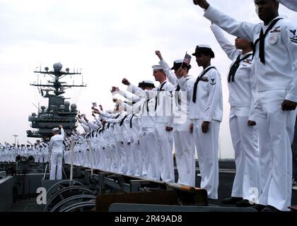 US Navy-Matrosen bewachen die Schienen, während die USS Theodore Roosevelt (CVN 71) von Freunden und Familienmitgliedern auf dem Pier als Held begrüßt wird Stockfoto