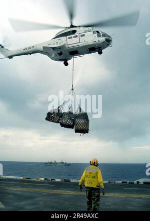 US Navy A SA-332 Super Puma Helikopter des Militärkommandos Sealift Gefechtslager Schiff USNS Spica (T-AFS 9) liefert Paletten mit Vorräten an USS Kearsarge (LHD 3) Stockfoto