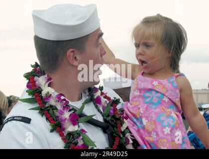 US Navy Yeoman 1. Klasse wird von seiner zweijährigen Tochter bei seiner Rückkehr nach Pearl Harbor begrüßt Stockfoto