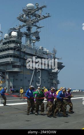 US Navy-Matrosen vom USS George Washington (CVN 73) Air Department handhaben während einer Übung im Cockpit einen Feuerwehrschlauch Stockfoto