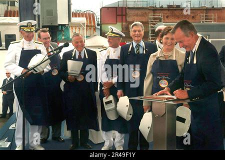 US Navy Präsident George H.W. Bush, begleitet von seiner Tochter und dem Sponsor Doro Bush Koch, schrieb seine Initialen mit Kreide auf eine Plakette, die dann von einem Schweißbrenner zurückverfolgt und dauerhaft befestigt wird Stockfoto