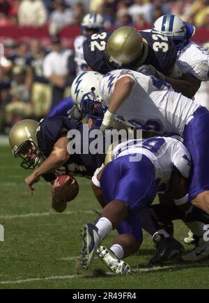 CRAIG Candeto, Senior Quarterback der US Navy, wird von Air Force Free Security Larry Duncan und Linebacker John Rudzinski angegriffen Stockfoto