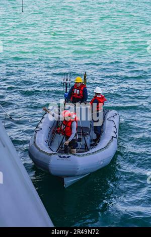 SINGAPUR (13. März 2023) Sonar Technician (Surface) 2. Class Kevan Thomas, Front, von Indian Head, Maryland, wirft eine Linie aus einem 7 Meter starren Schlauchboot (RIB), während das RIB von der Hafenseite des kleinen Kampfschiffs USS Oakland (LCS 24) der Unabhängigkeitsklasse während eines kleinen Bootstrainings in Singapur, 13. März, ausfährt. 2023. Oakland, Teil des Destroyer-Geschwaders 7, befindet sich in einem Rotationseinsatz und operiert im US-Flottengebiet 7., um die Interoperabilität mit Alliierten und Partnern zu verbessern und als einsatzbereite Eingreiftruppe zur Unterstützung einer freien und offenen Region Indo-Pazifik zu dienen. Stockfoto