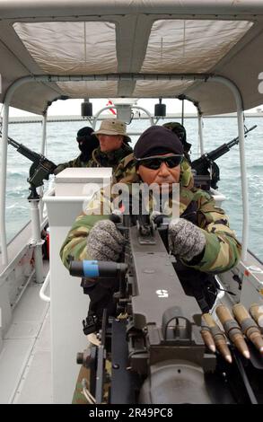 US Navy Crewmitglieder an Bord eines Patrouillenfahrzeugs, das der Küstenwache für Hafensicherheit, Einheit 3 Zero Seven (PSU 307), zugewiesen wurde, überwachen Aktivitäten rund um den Kuwait Naval Base Stockfoto