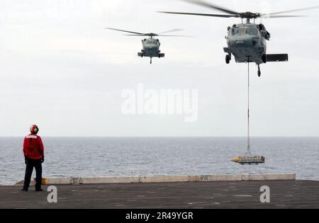 US Navy MH-60s Knighthawk Hubschrauber, die den Drachenwalen des Helicopter Combat Support Squadron Acht (HC-8) zugeteilt sind, fliegen zwischen dem Flugzeugträger USS Harry S. Truman (CVN 75) Stockfoto