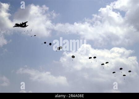 US NAVY A U.S. Air Force C-130 Hercules lässt eine große Reihe Fallschirmjäger fallen, die den USA zugeteilt wurden Army 82. Airborne vor der Menge beim 2004 Joint Service Open House Stockfoto