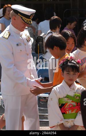 US Navy Commander Siebte Flotte, Vizeadmiral Robert F. Willard, schüttelt einem japanischen Jungen die Hand im Gyokusenji Tempel Stockfoto