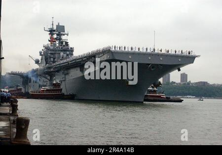 US Navy-Matrosen und Marines bewachen die Schienen, während das amphibische Sturmschiff USS Iwo Jima (LHD 7) am Pier ankommt Stockfoto