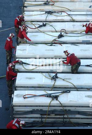 Die Besatzungsmitglieder des US Navy Weapons Department erhalten auf dem Flugdeck der USS George Washington (CVN 73) Waffen vom militärischen Sealift-Kommandoschiff USNS Supply (T-AOE 6) Stockfoto