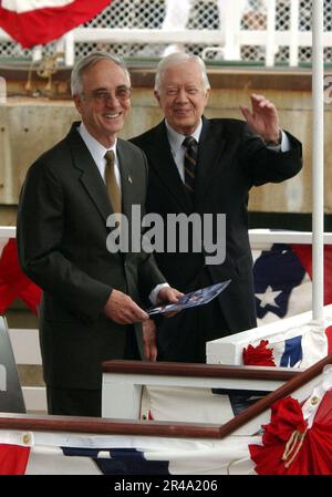 US Navy ehemaliger Präsident Jimmy Carter (rechts) winkt der Menge zu, während er und Navy Secretary Gordon England ihre Plätze für die Taufe einnehmen Stockfoto