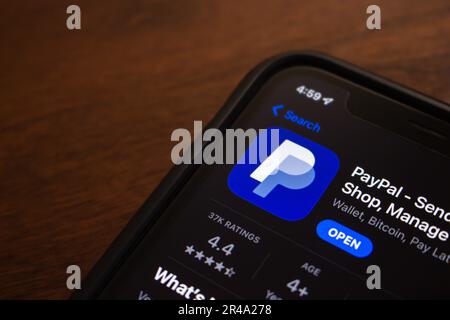 PayPal-App in einem App Store auf einem iPhone. PayPal ist eine Zahlungsplattform, mit der Benutzer Zahlungen über ein Online-Geldtransfersystem vornehmen können Stockfoto