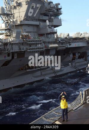 US Navy Landing Signal Enlisted (LSE), das dem schnellen Kampfschiff USS Seattle (AOE 3) zugewiesen ist, sendet ein Startsignal an einen MH-60s Knighthawk Stockfoto