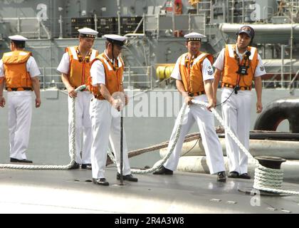 MITARBEITER DER US Navy Line an Bord des japanischen U-Boots Narushio (SS 595) sichern die Leitungen nach der Ankunft in Pearl Harbor, Hawaii für einen Hafenanruf Stockfoto