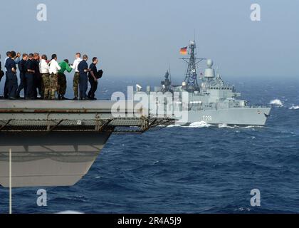 US Navy Matrosen versammeln sich auf dem Cockpit des Flugzeugträgers USS Enterprise (CVN 65), um zu beobachten, wie die deutsche Fregatte FFG Niedersachsen (F 208) als Teil einer Formation der USA neben ihnen dampft Navy und OT Stockfoto