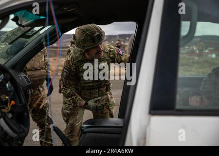 Kosovo Force (KFOR) Soldat mit der britischen Armee prüft die Reaktionsfähigkeit eines KFOR-Patienten während der Operation Cavalry Guardian Notfallschulung in der Nähe von Camp Novo Selo, Kosovo, am 10. Januar 2023. Während des Trainings wetteiferten Soldaten aus Österreich, den USA und Großbritannien um die beste Reaktion auf ein Notszenario mit Rollenspielern und Notfallpersonal der KFOR. Stockfoto