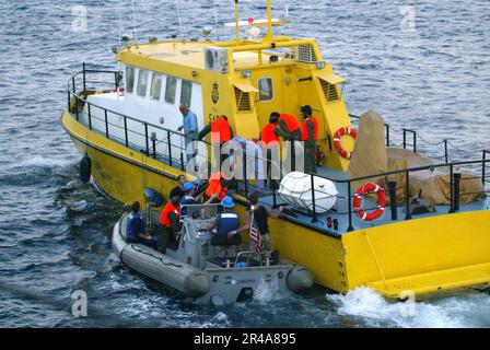 US Navy-Matrosen des geführten Raketenkreuzers USS Vicksburg (CG 69) platzieren während der Rückführung von sechs iranischen Marinern ein RHIB neben einem Patrouillenfahrzeug der iranischen Zivilbehörden Stockfoto