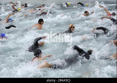 Die US-Navy-Konkurrenten begeben sich auf das Wasser für die erste Etappe des Alba Olympischen Triathlons in Alba, Bahrain Stockfoto