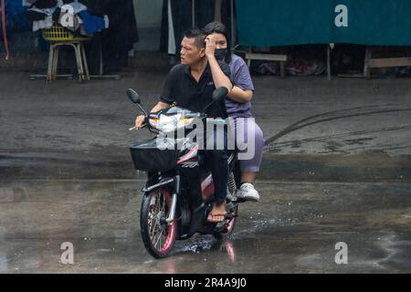 SAMUT PRAKAN, THAILAND, MAI 10 2023, Ein Paar fährt im Regen Motorrad Stockfoto